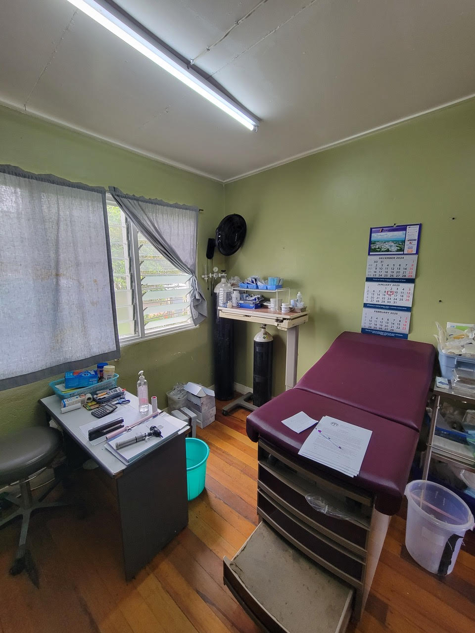 Interior of a community medical clinic in Papua New Guinea, with an examination table and supplies